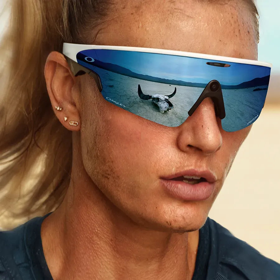 Une femme posant avec les lunettes Oakley Meta Vanguard avec monture blanc mat et verres Prizm™ Sapphire.